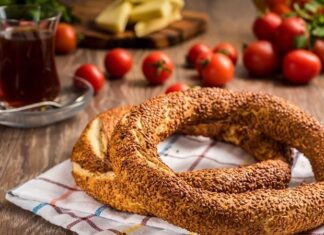 Türkiye’de sokak lezzetleri denildiğinde akla gelen ilk tatlar arasında simit ve açma yer alır. Günün her saatinde ulaşılabilen bu iki hamur işi, yalnızca pratik bir atıştırmalık olmanın ötesinde, şehir yaşamının ritmini belirleyen önemli unsurlardan biri olarak görülür. Sabah işe yetişmeye çalışan bir memurun elinde, okul yolunda koşan bir öğrencinin çantasında ya da sahil kenarında çay eşliğinde tüketilen bu lezzetler, toplumsal hafızanın da güçlü bir parçasıdır. Konulu bir haber görseli.